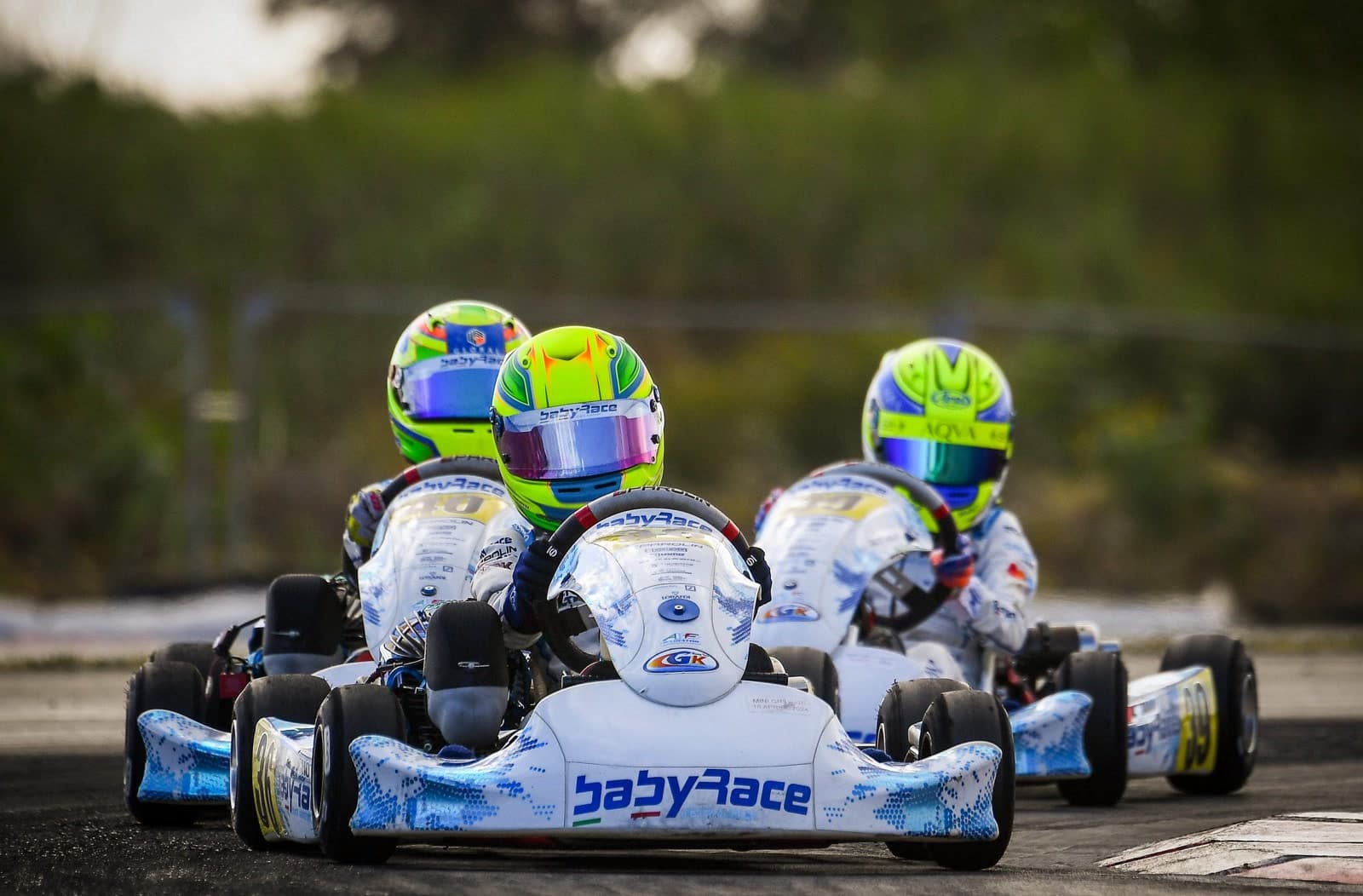 Three Babyrace karts racing side by side hunting for grip on the racing line