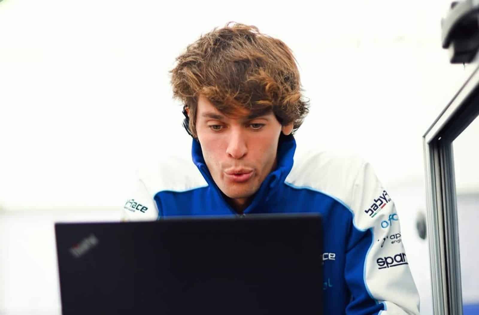 Alessio Lorandi in Babyrace race suit focused on telemetry data on a laptop