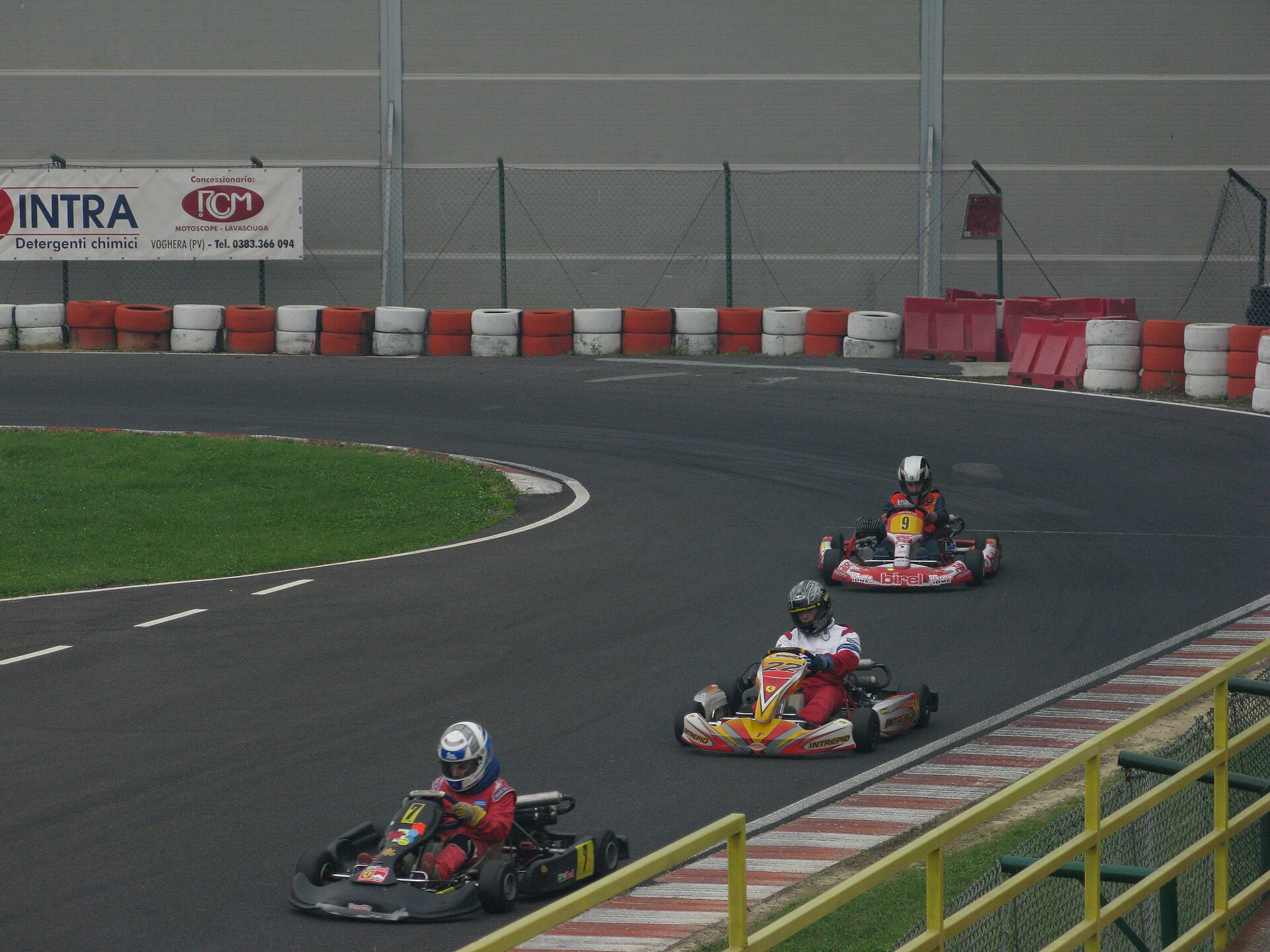 Elevated wide view of a kart circuit showing corner kerbing, camber and layout