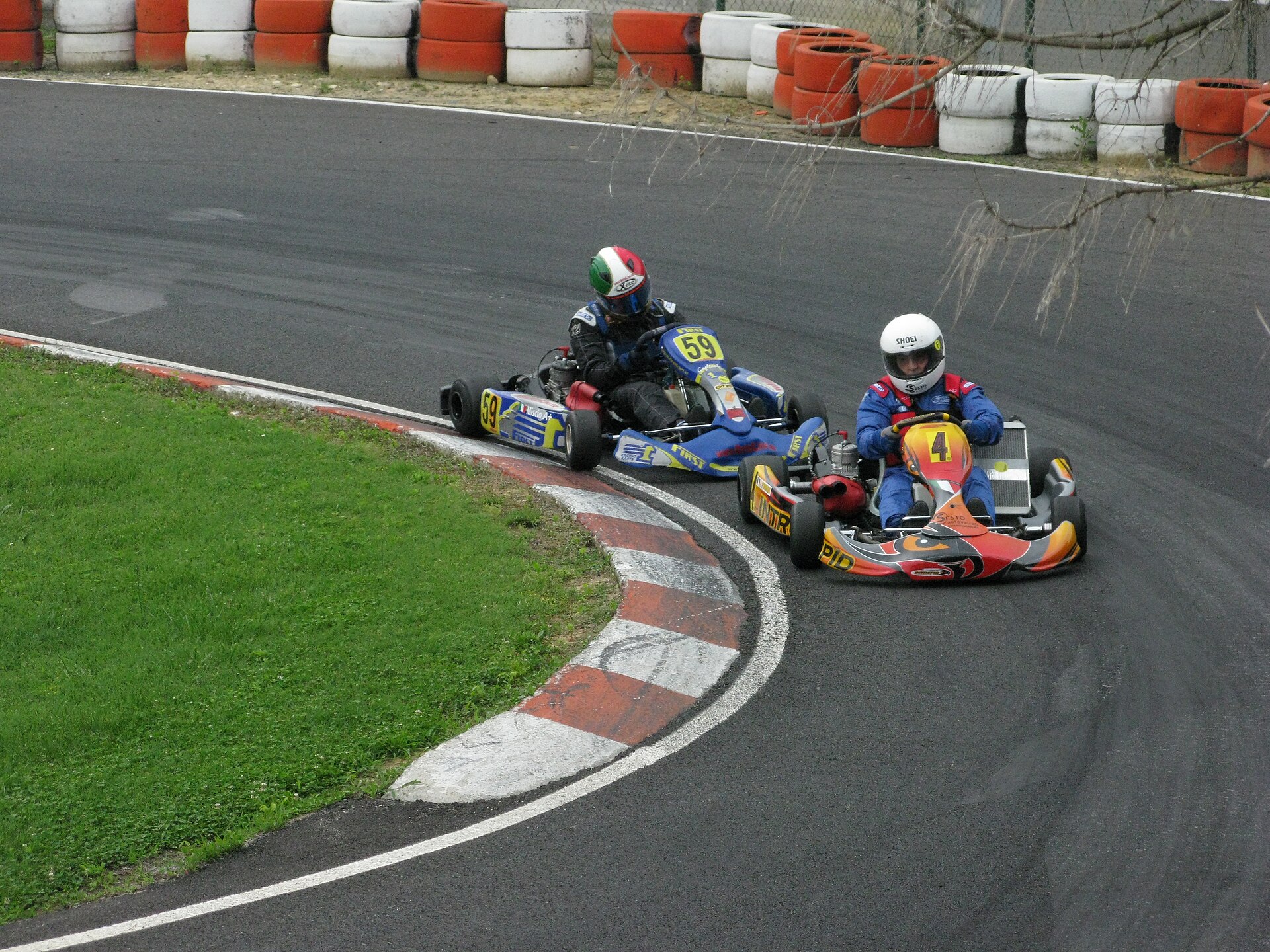 Two karts through a hairpin staying off the raised apex kerb