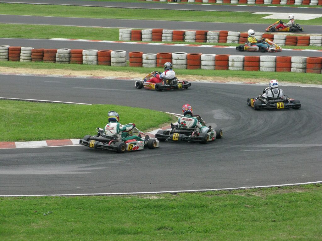 Karts cornering with the inside kerb in use, wheels running right at the kerb edge